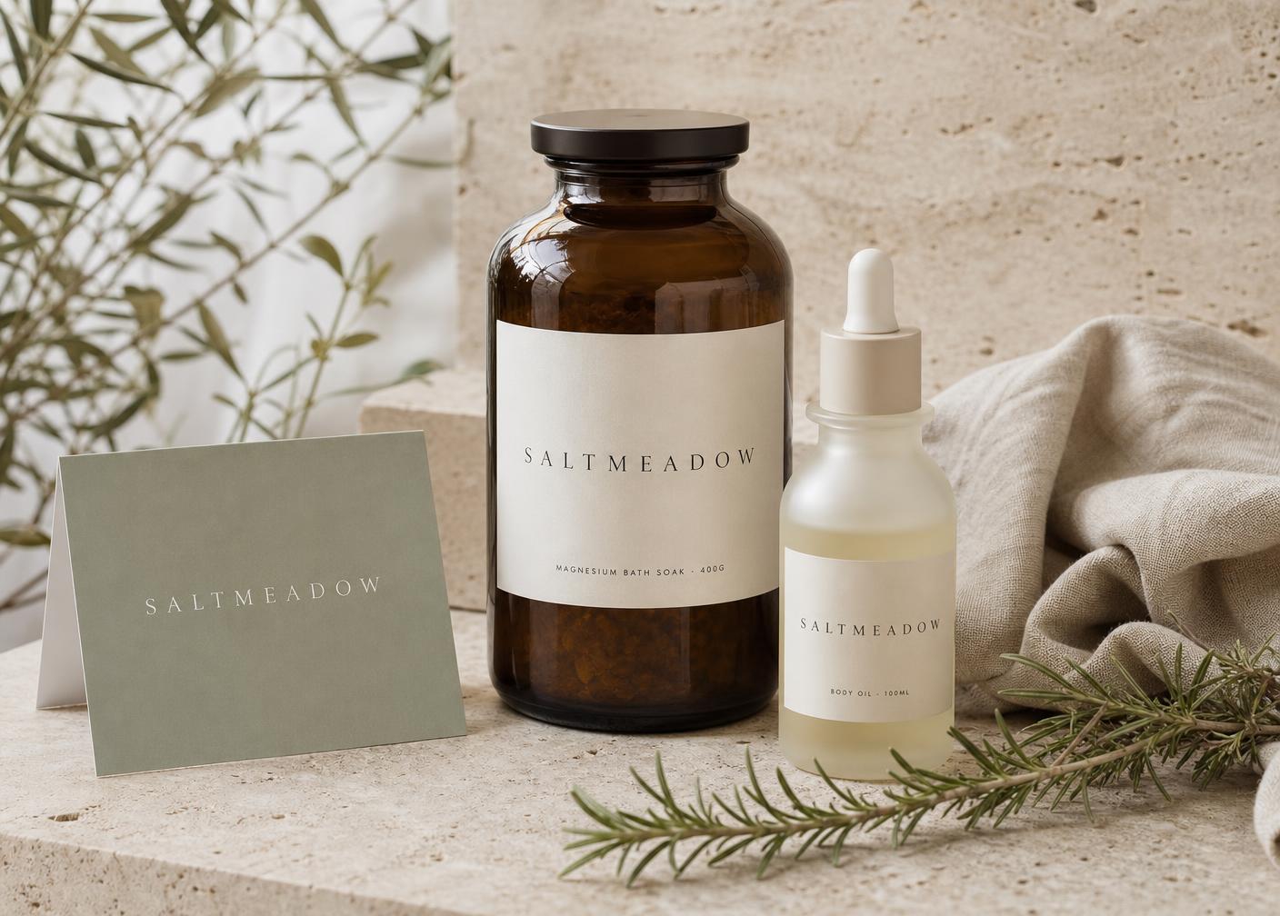 Saltmeadow bath soak jar and body oil bottle on travertine